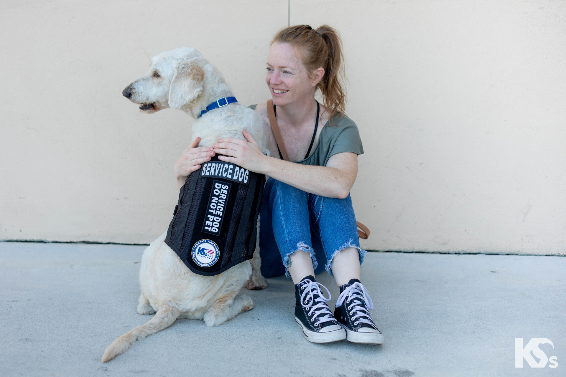 A veteran embracing her service dog in its K9s For Warriors vest